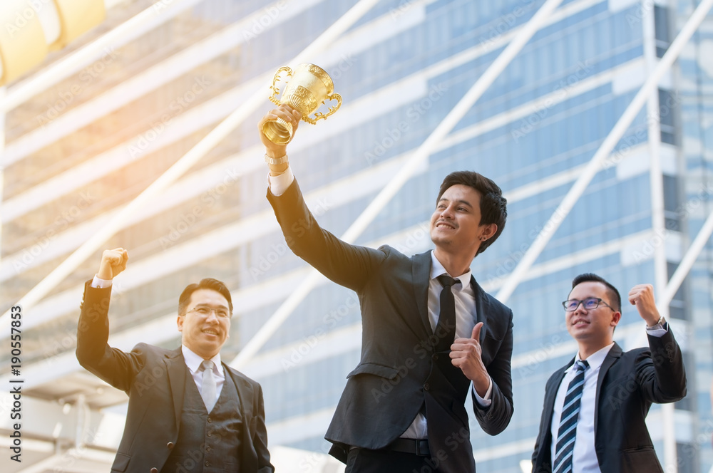 Success business man holding golden trophy cup with right hand ...
