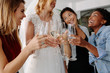 © Jacob Lund - Woman in bridal gown toasting champagne glasses with friends
