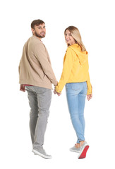 Wall Mural - Young couple in casual clothes walking on white background