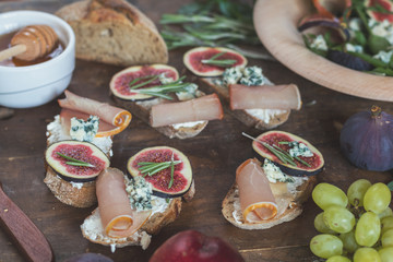 Wall Mural - easy diet salad with arugula, figs and blue cheese on a brown wooden surface. sandwiches with ricott