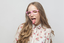 Playfully Young Woman In Pink Eyeglasses, Looking At Camera, Tongue Out And Flirt With You.