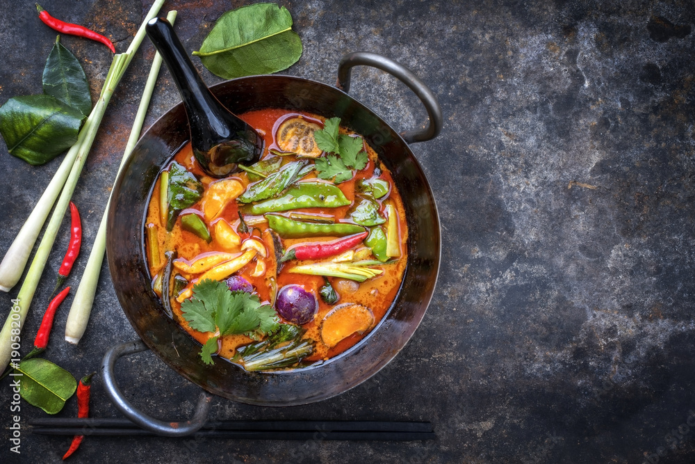 Traditional Thai kaeng phet red curry with vegetables as top view in a wok with copy space right - obrazy, fototapety, plakaty 