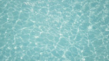 Fototapeta Sypialnia - Water in swimming pool rippled water detail background. Water in swimming pool with sun reflection. Blue swimming pool rippled water detail
