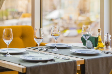 Served table in restaurant. Glasses, fork, knife served for lunch in an Italian restaurant with cozy interior