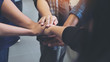 © Farknot Architect - Closeup image of business team standing and joining their hands together in office