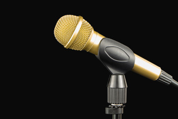 Wall Mural - Golden microphone on a stand on a black background