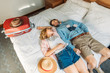 © LIGHTFIELD STUDIOS - high angle view of couple of tourists lying on bed in hotel room