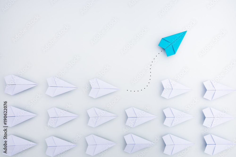 Group of paper planes in one direction and with one individual pointing in the different way. Business concept for innovative solution. - obrazy, fototapety, plakaty 