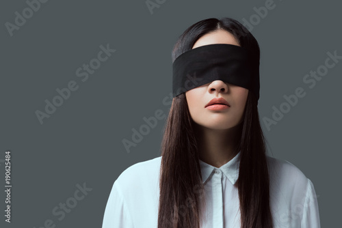 Fotografía young woman wearing black blindfold isolated on grey