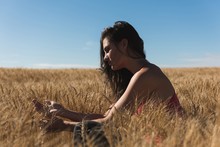 Woman Holding Wheat Crop In Field