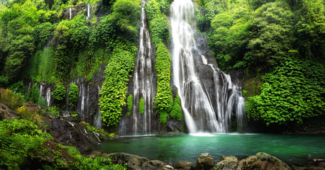 jungle waterfall cascade in tropical rainforest with rock and turquoise blue pond. its name banyumal