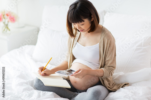 Fotografia, Obraz pregnant woman with fetal ultrasound image at home