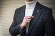 Man in turtleneck sweater suit holding his lapel and posing