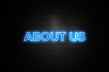 About Us Neon Sign On Brickwall