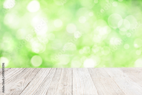 Wooden deck with blurred green garden background