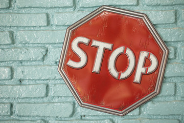 Stop sign on the green wall.