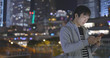 © leungchopan - Young Man using smart phone in city at night