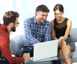 © ASDF - Business colleagues discussing on report with laptop on table