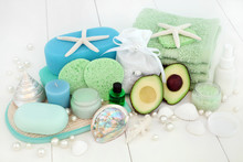 Avocado Skincare And Body Care Beauty Treatment With Bath Salts, Sponges, Face Cloths, Aromatherapy Essential Oil, Body Lotion, Facial Cream, Soap And Decorative Shells On White Wood Background.