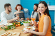 © pressmaster - Pretty young housewife with wineglass of juice sitting by served table with her guests