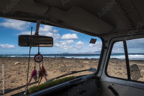Fotografie, Obraz interior of a minivan with dreamcathcer and ocean outside
