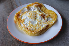 Roti Canai With Egg  On The Plate Over Dining Table