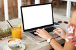 © WHstudio Leushin N - Cropped imgae of female employee types on keyboard of modern portable laptop computer with blank copy screen, sits at table with juice and cappuccino, works on financial report or checks email