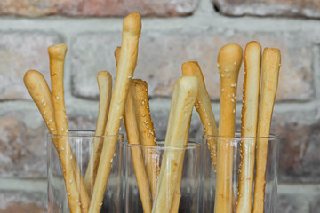 Traditional italian home made grissini with spouts on rustic brick wall background with copy space