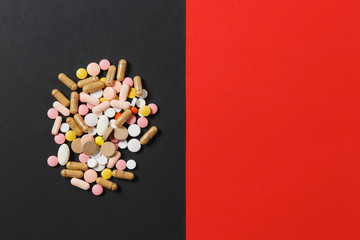 Medication white colorful round tablets arranged abstract on red black background. Aspirin, capsule pills for design. Health, treatment, choice healthy lifestyle concept. Copy space for advertisement.