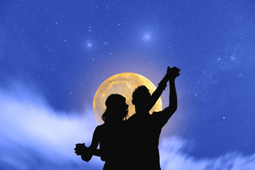 Wall Mural - young couple dancing under the moonlight and stars.
