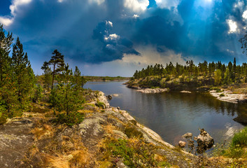 Storm clouds. Summer in Finland. Rocky bay. Travel Norway and Finland. Summer in the wild. Rocky shore with pine trees. Norway.