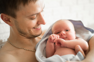 portrait of father with newborn baby at home . deadpan raw photo nofilter