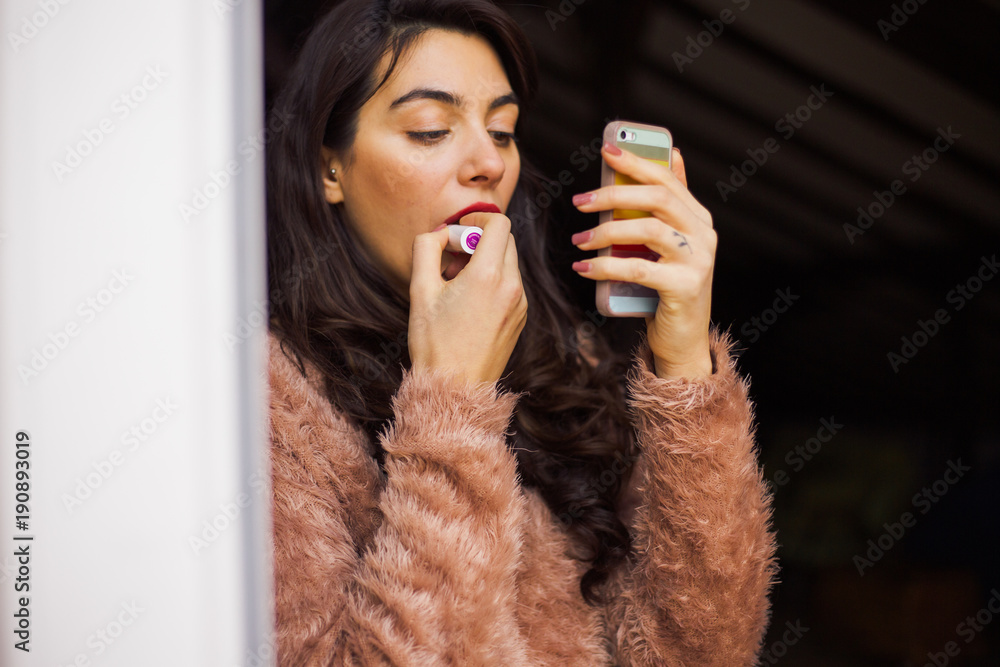 Girl putting red lipstick - obrazy, fototapety, plakaty 