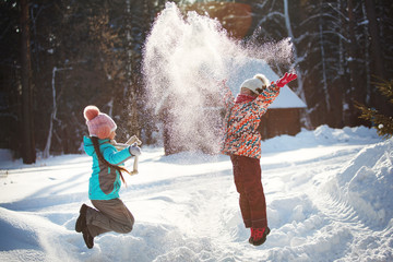 Two little girls are playing in the winter park