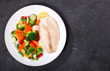 Poster - plate of fried fish fillet with vegetables, top view