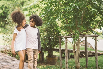 Wall Mural - Children Friendship Togetherness Smiling Happiness Concept.Cute african american little boy and girl hug each other in summer sunny day