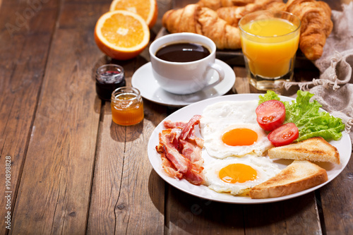 Fotomural breakfast with fried eggs, croissants, juice, coffee and fruits