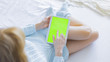 © kristinav85 - Woman at home relaxing reading on the tablet with pre-keyed green screen