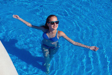 Wall Mural - teen girl relaxing near swimming pool