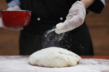 the cook makes flour for baking on the table