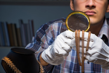 Young male jeweller working at night in his workshop