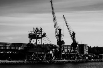 Gdansk shipyard, Poland. Retro style black and white. Cranes, old shipyard buildings, rusty structures.