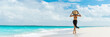 © Maridav - Luxury travel summer beach vacation woman walking in black beachwear skirt and hat on paradise white sand Caribbean beach. Lady tourist on Caribbean holiday vacation resort. Banner panorama landscape.