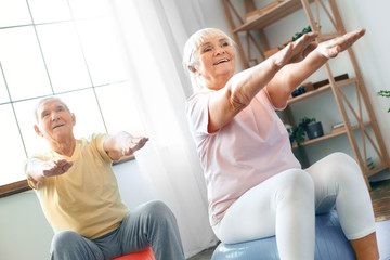 Wall Mural - Senior couple exercise together at home doing aerobics hands in front