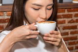 Fototapeta  - Woman drinking coffee at coffee shop