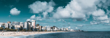 Panorama Of Summer Coastline: Leblon, Ipanema, And Arpoador Beaches Stretched Into Distance; People Are Swimming in The Ocean, Enjoying Sun, Tanning; Many Hotels And Residential Houses In Background