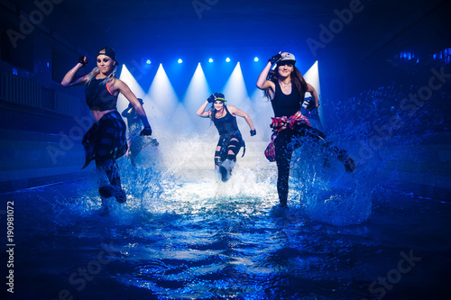 Fotomural Performance on the water of a dance group against the background of club light