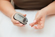 © Parilov - Glucometer. Woman checks blood sugar level for diabetes, insulin levels