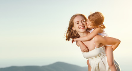 Happy family in summer outdoors.   mother  hug child daughter and laughing