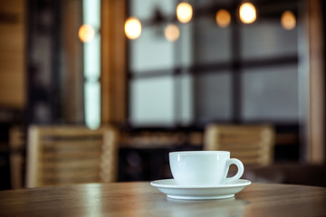 White cup of coffee at the cafe interior - vintage style effect picture